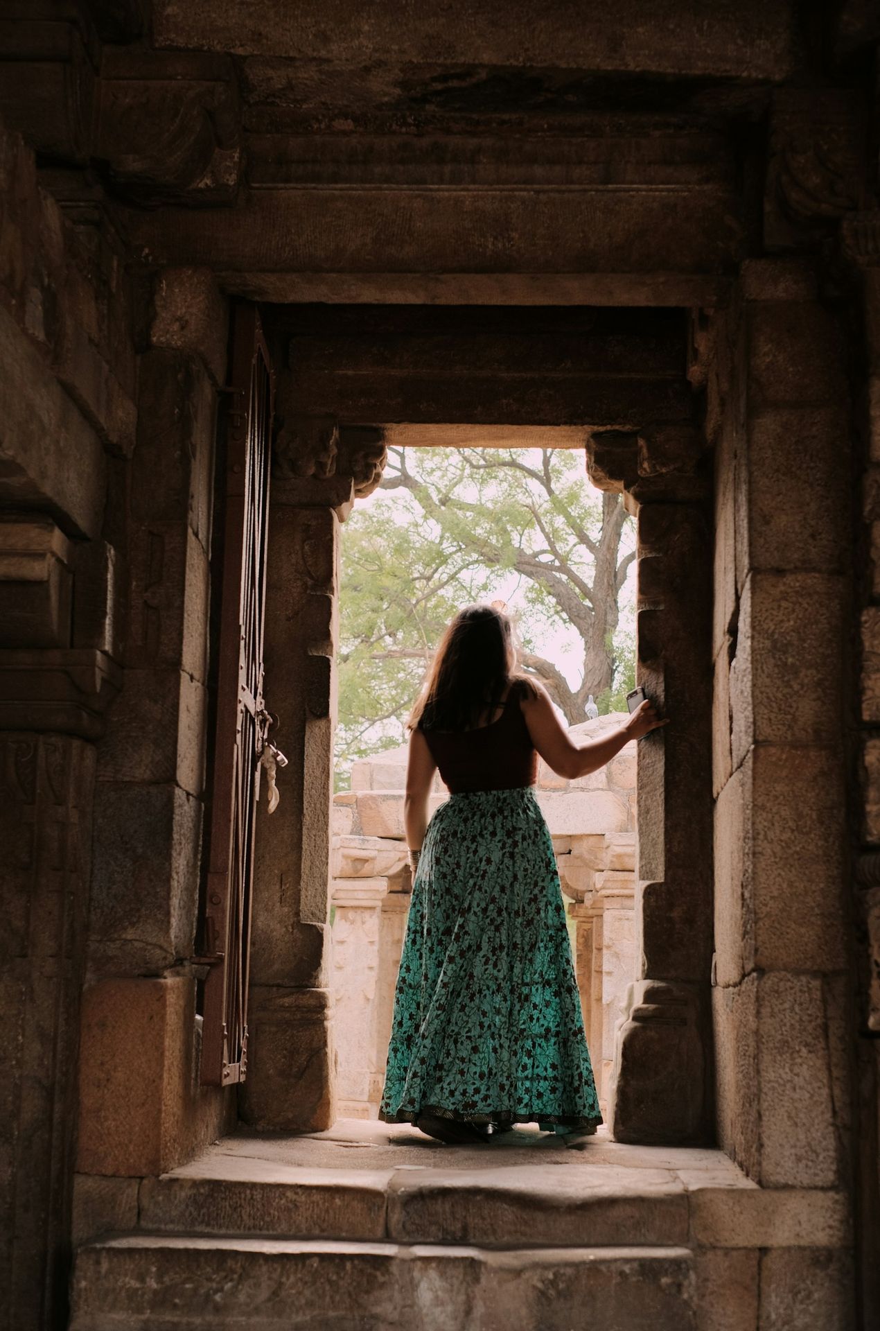 a woman in a long dress standing in a doorway